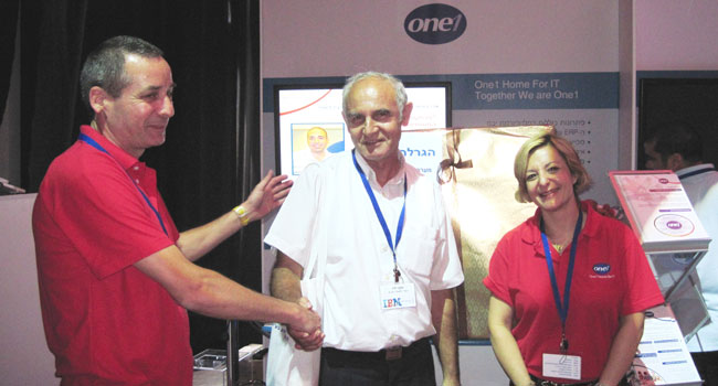 בהגרלה שבוצעה בביתן של חברת One1 בכנס זכה יעקב וידר מחברת אל-על במקרר יינות. באמצע: יעקב וידר ולצידו שמחה פוסטובסקי, מנהל מוצרי יבמ בחברת One1 וגילי שלזינגר, סמנכ"ל שיווק ומכירות ב-One1ERP