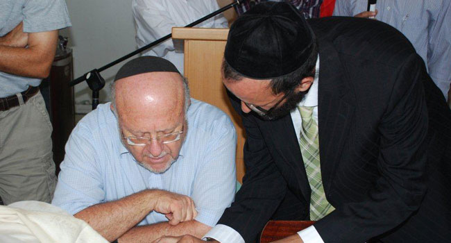 שלמה איזנברג (משמאל) משלים את כתיבת ספר התורה