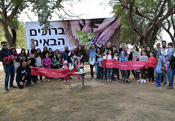 עובדי אורקל וילדיהם, רגע לפני שלקחו את אתי החפירה ונטעו. צילום: כרמית מרי